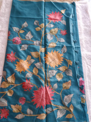 Floral patterned fabric with pink, orange, and green flowers on a blue